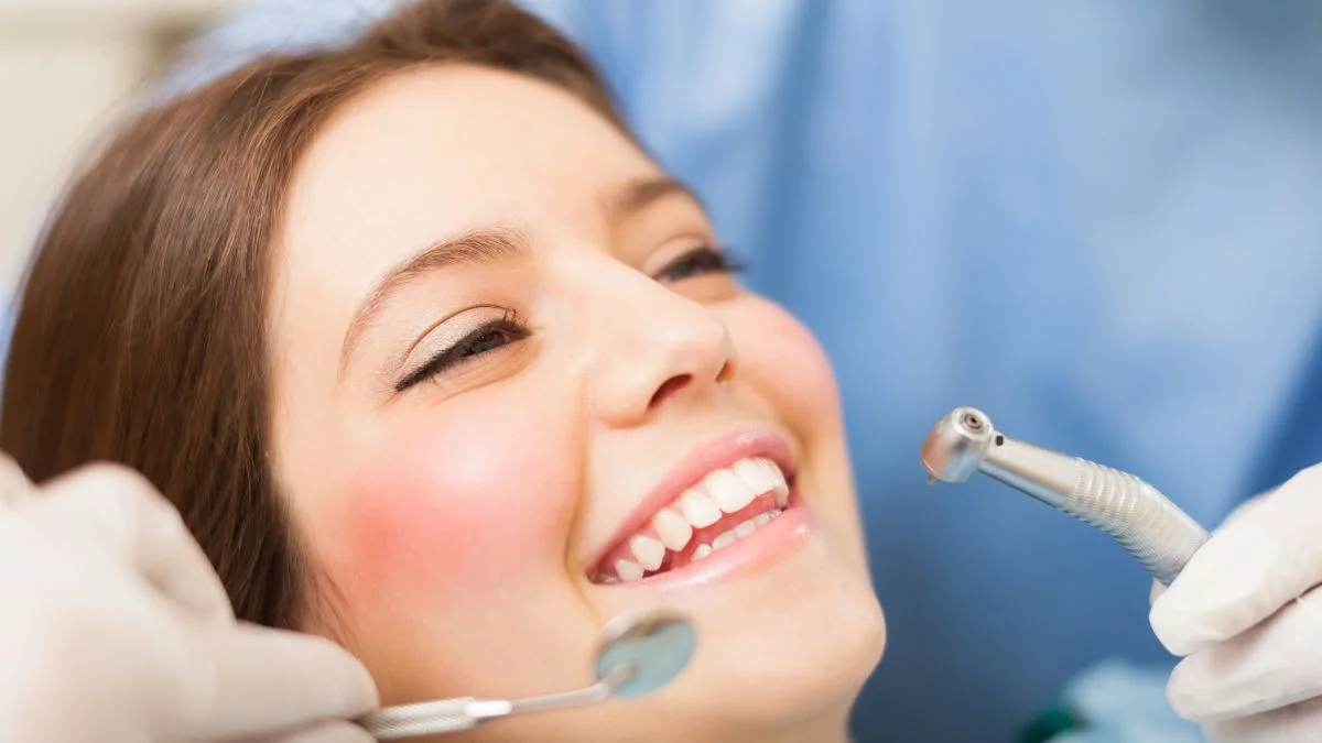 Paciente sorrindo sentada na cadeira odontológica