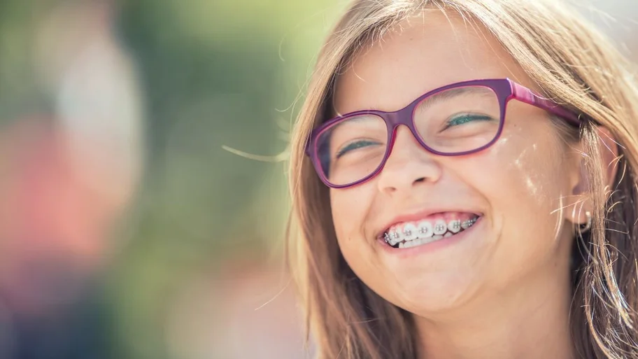 Adolescente com aparelho ortodôntico sorrindo